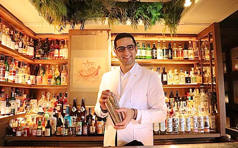 日本のウイスキー、焼酎、日本酒が並ぶ「OMAKASE(おまかせ)カウンター」に立つシーガル氏