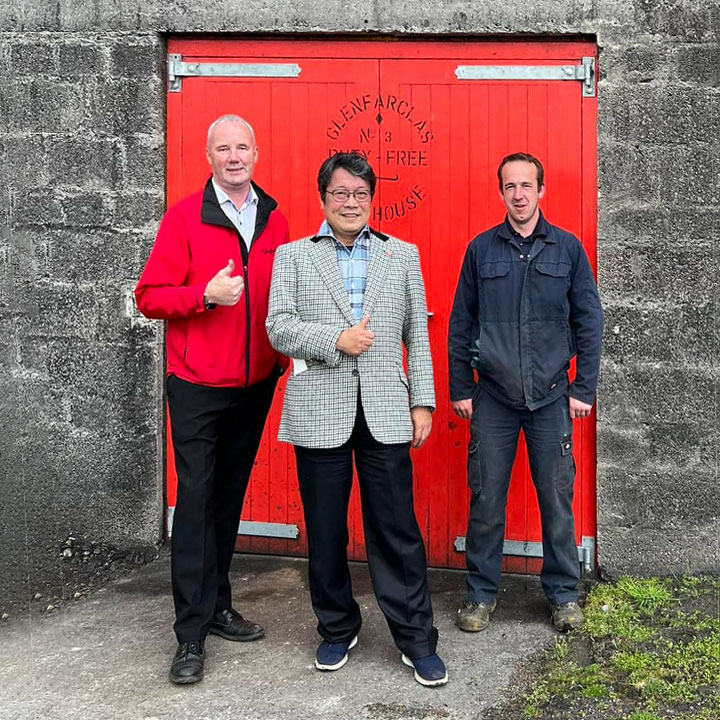 グレンファークラス蒸留所のグローバルブランドアンバサダー、イアン・マクウィリアムさん(左)といっしょに蒸留所前で撮影する山岡秀雄。